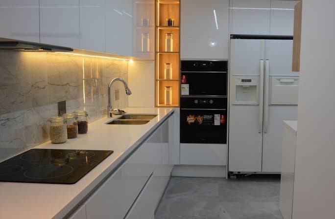 Cocina moderna con grifo, encimera e iluminación led instalados